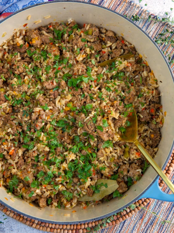 Cajun Dirty Rice in a dutch oven with a gold serving spoon