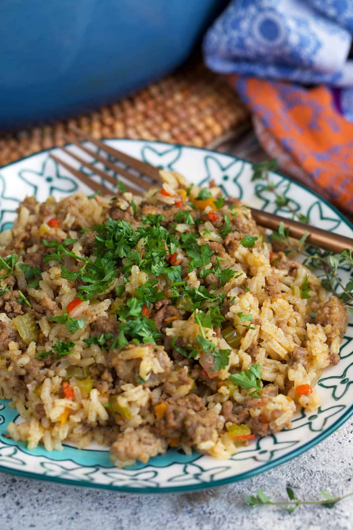 Dirty Rice on a plate topped with parsley and a fork.