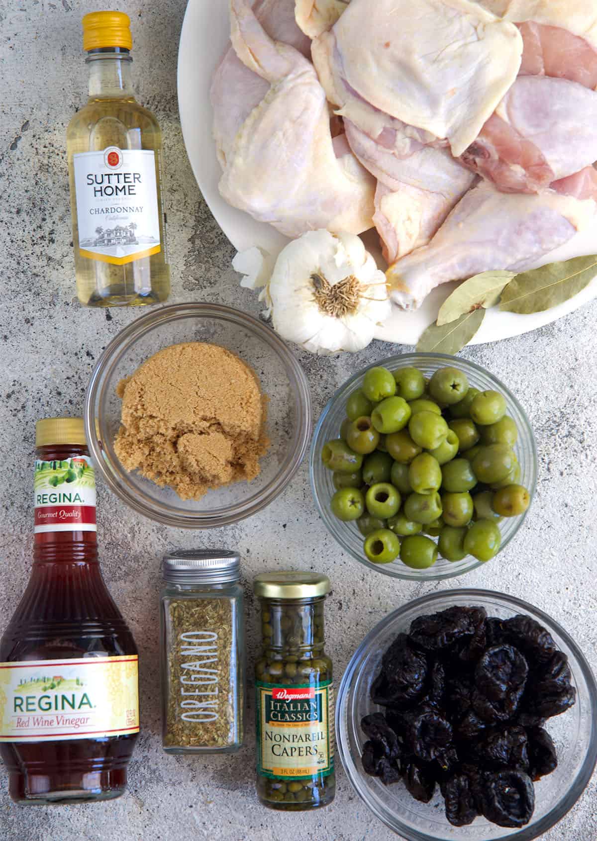 Ingredients for Chicken Marbella on a gray background
