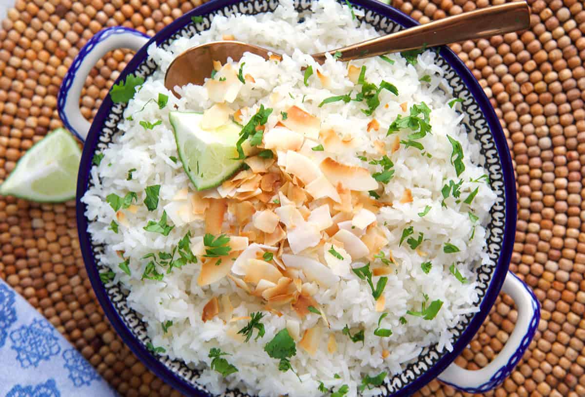 coconut rice with a copper serving spoon in a polish pottery dish