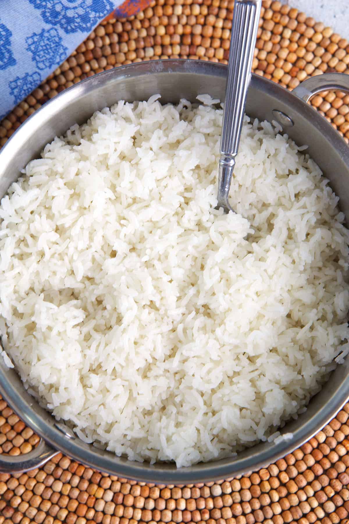 coconut rice in a saucepan after being cooked and fluffed with a fork