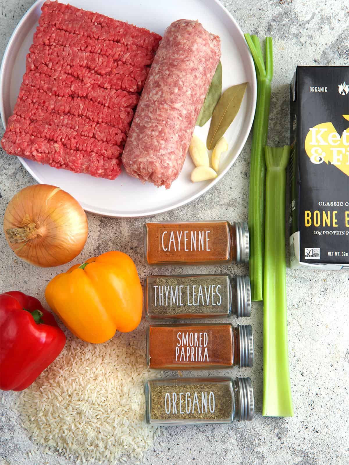 Ingredients for cajun dirty rice on a gray board.
