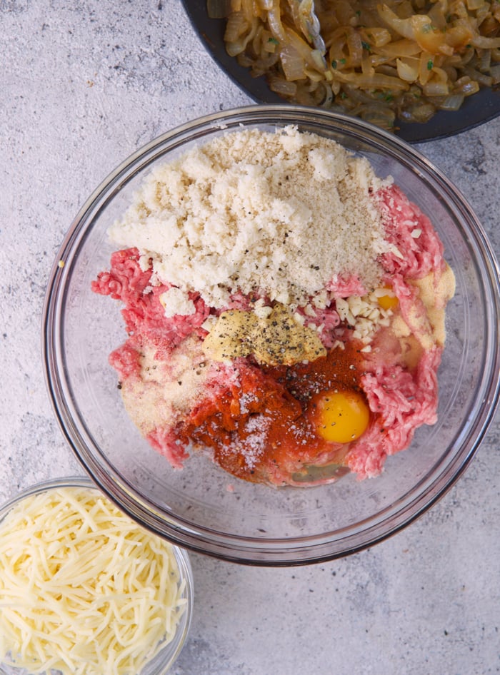 Ingredients for French onion meatloaf in a glass mixing bowl