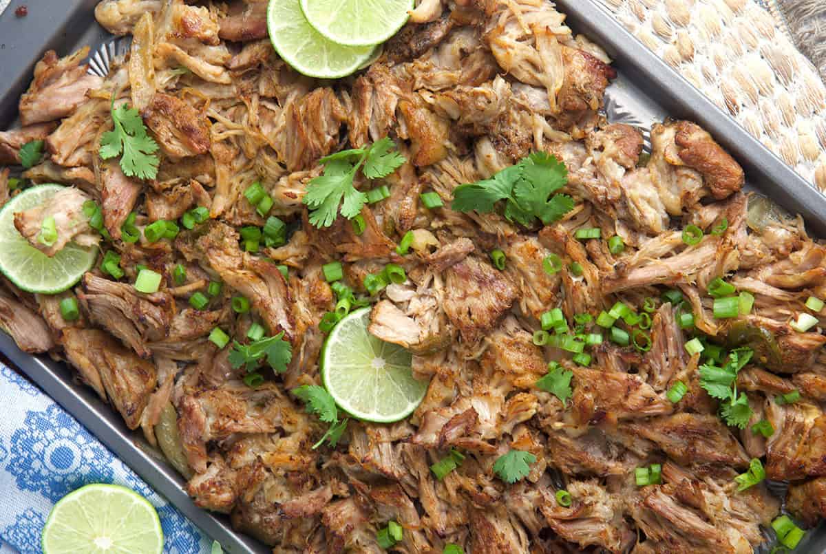 shredded pork carnitas on a baking sheet after being broiled in the oven until crispy