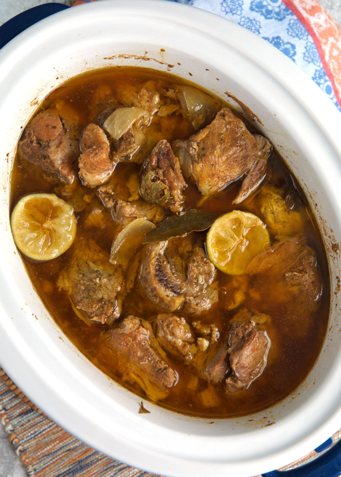 step 2 of pork carnitas after being cooked in a slow cooker and ready to be shredded.