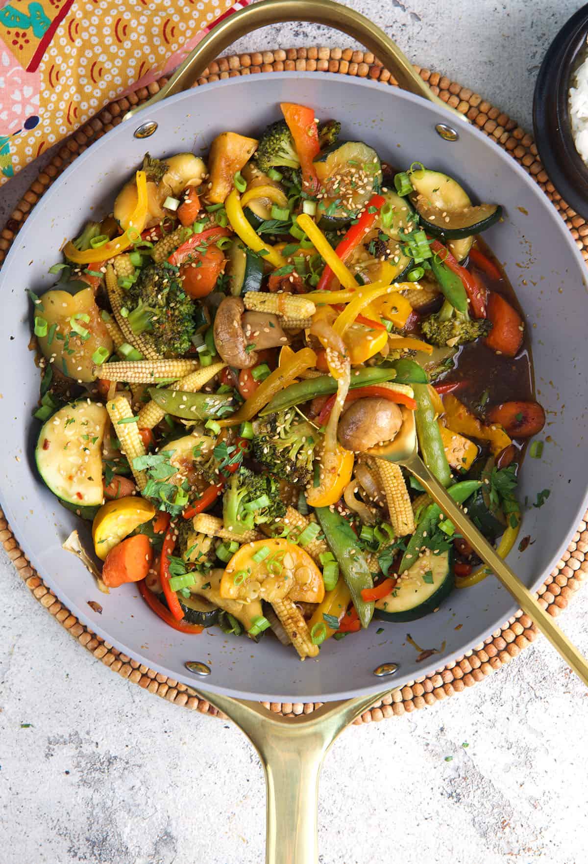 Homemade Vegetable Stir Fry in a wok with a serving spoon.
