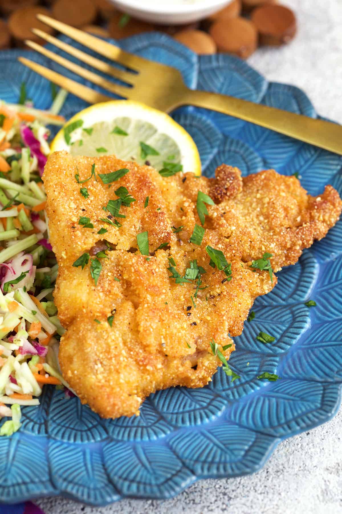 crispy fried catfish on a blue plate with coleslaw