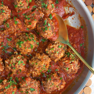 Porcupine meatballs in a steel skillet with a serving spoon