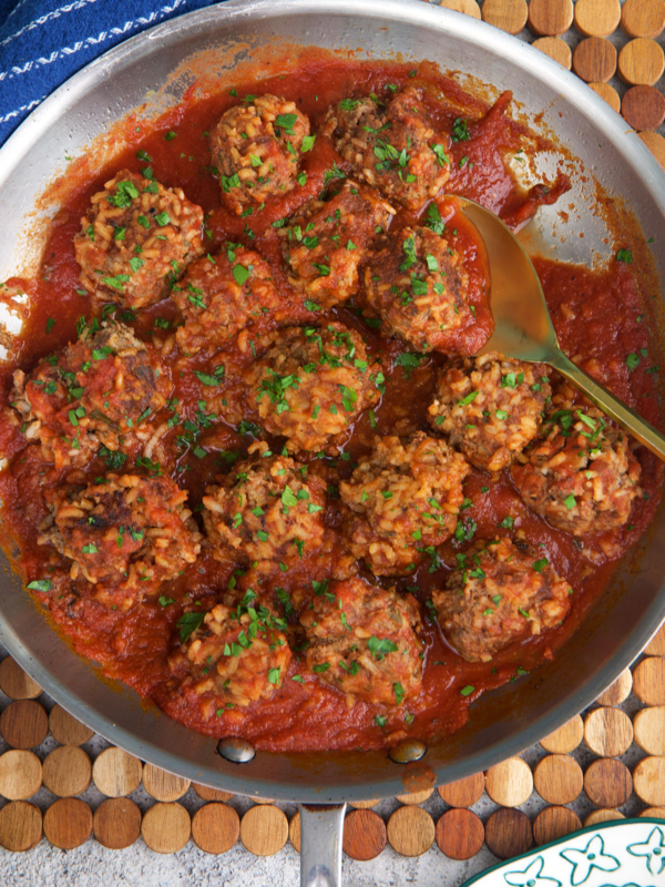Old Fashioned Porcupine Meatballs in a steel skillet with a gold spoon