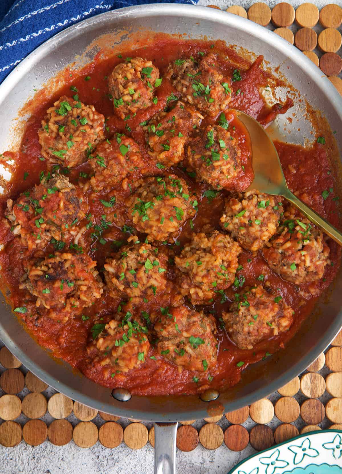 Old Fashioned Porcupine Meatballs in a steel skillet with a gold spoon