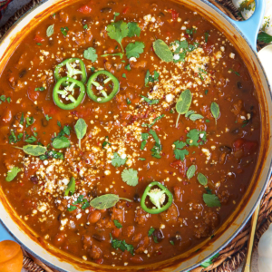 Pumpkin Chili with Sausage and black beans in a blue dutch oven.