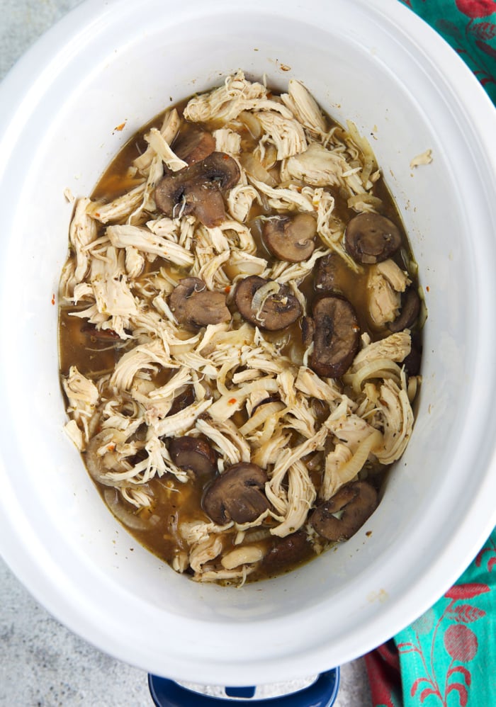 shredded cooked chicken with mushrooms in a crock pot