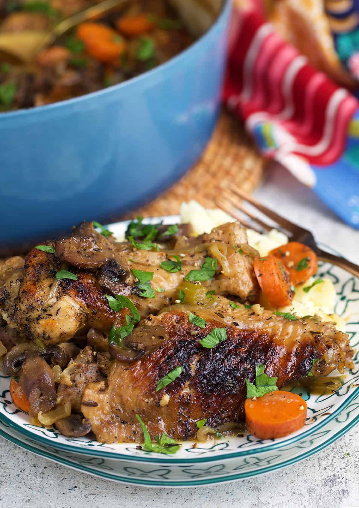 braised turkey wings with gravy and vegetables on a pile of mashed potatoes