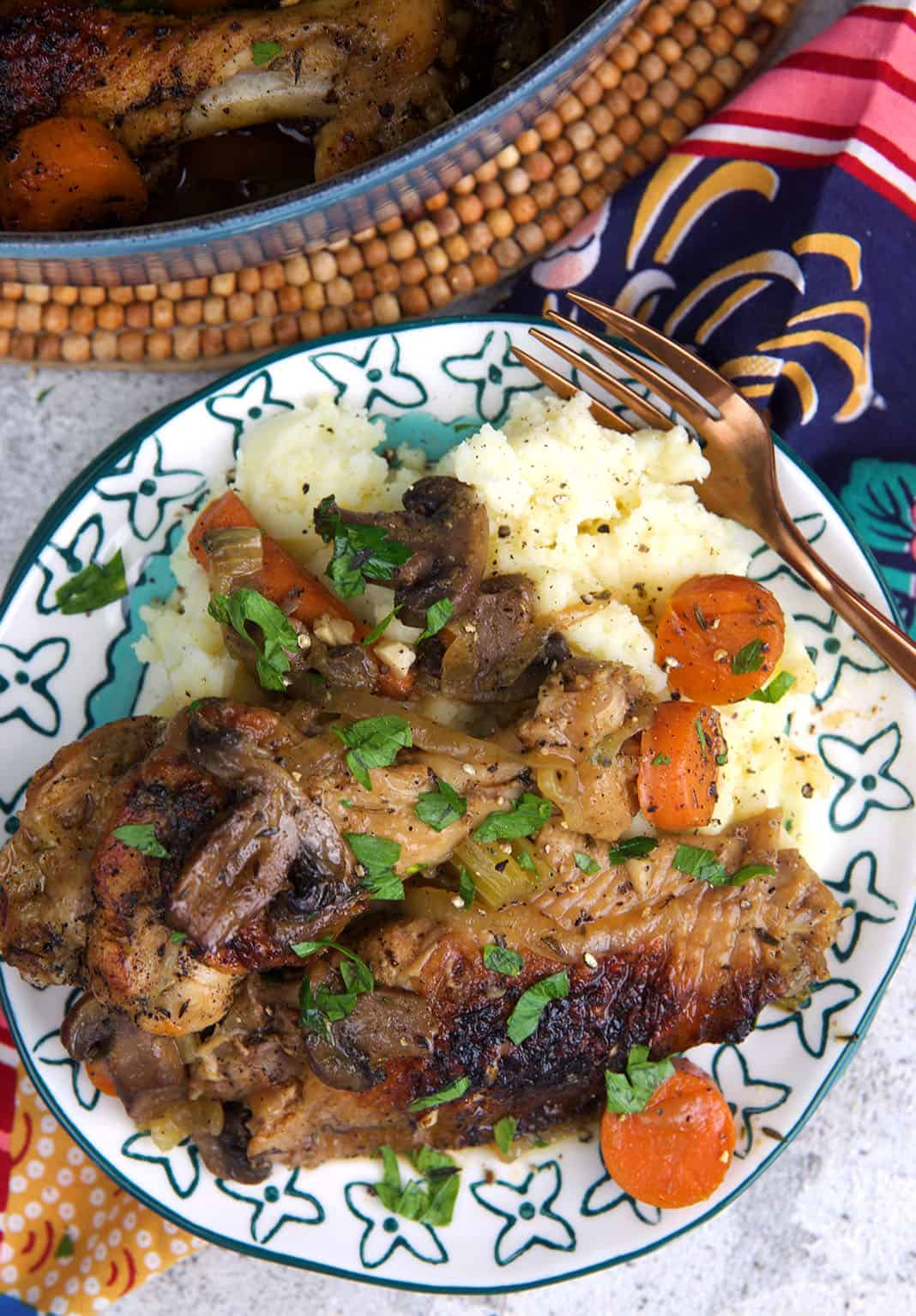 Baked Turkey Wings with gravy on a plate with mashed potatoes and sliced carrots