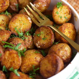 Air fryer roasted potatoes in a serving bowl with a fork