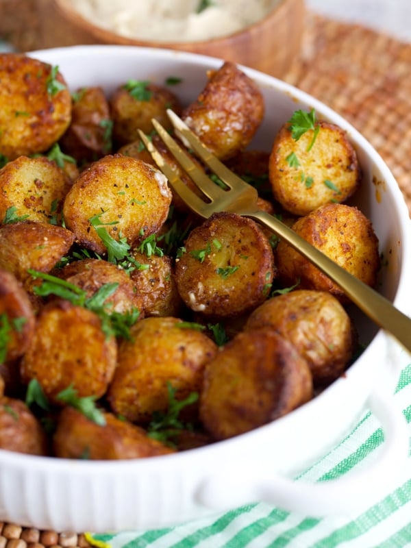 Crispy paprika roasted potatoes in the air fryer served in a white bowl with a gold fork