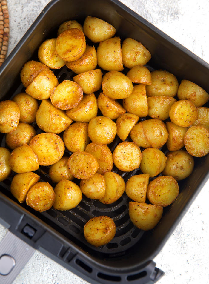 baby potatoes in an air fryer basket before being fried