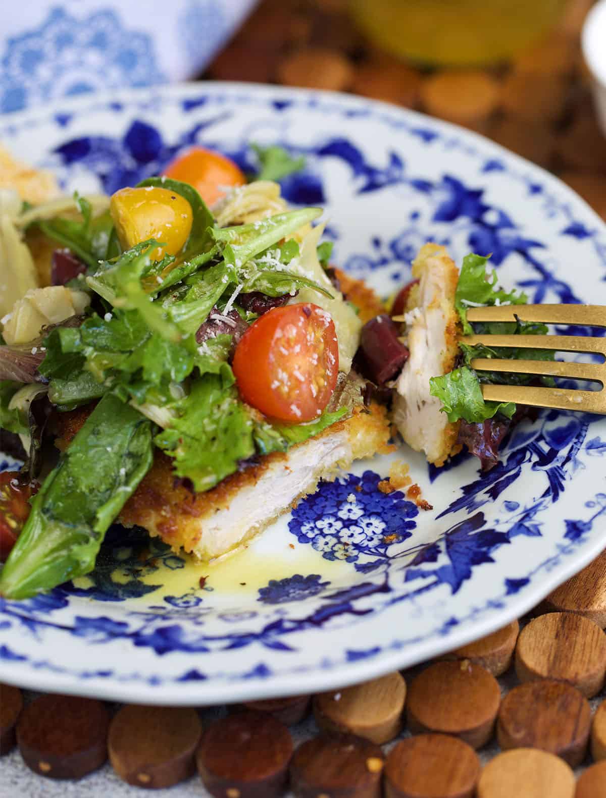 Chicken milanese with a bite on a fork.