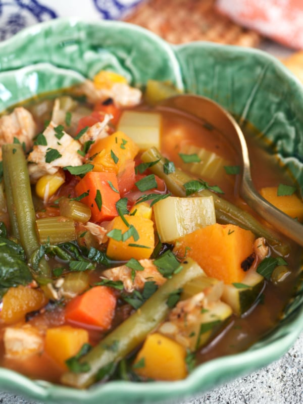 Chicken and vegetable soup in a cabbage bowl with a copper spoon