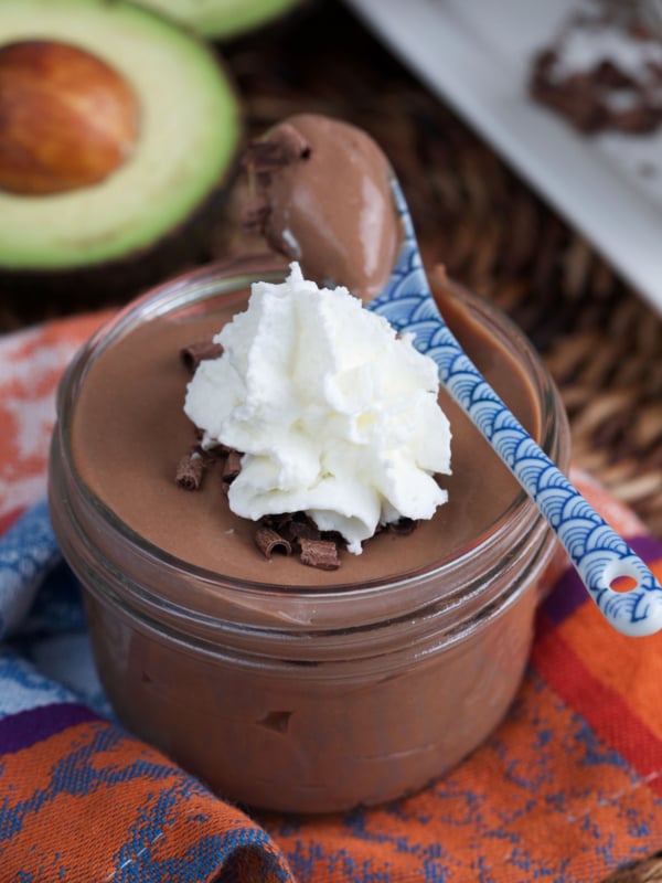 Chocolate Protein Pudding in a glass dish with a dollop of whipped cream on top.