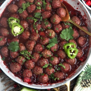 Cranberry Meatballs in a skillet with sliced jalapeno and cilantro on top
