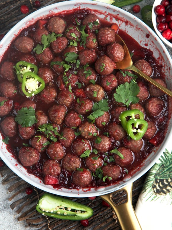 Cranberry Meatballs in a skillet with sliced jalapeno and cilantro on top