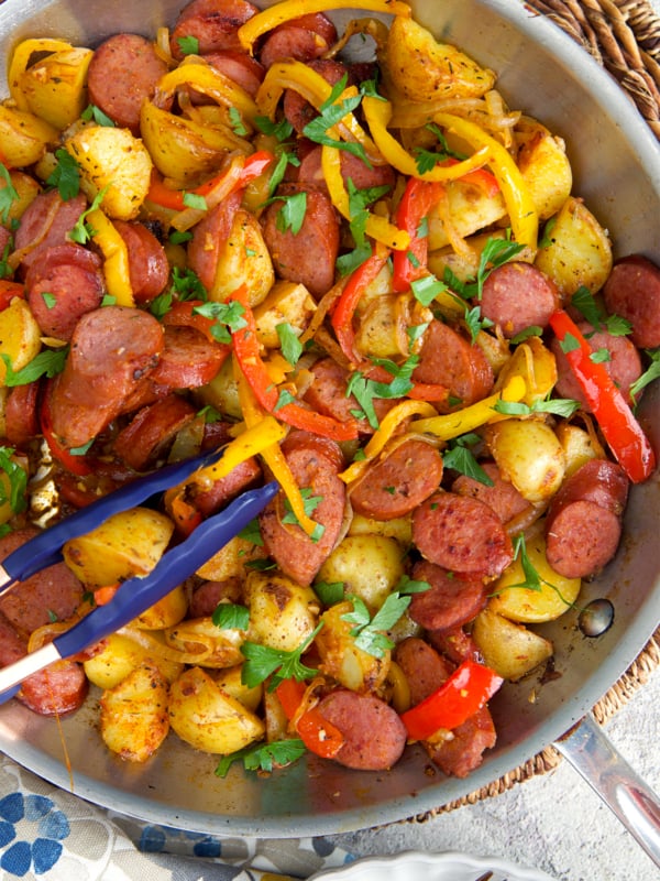 Kielbasa and Potatoes in a skillet being sautéed.