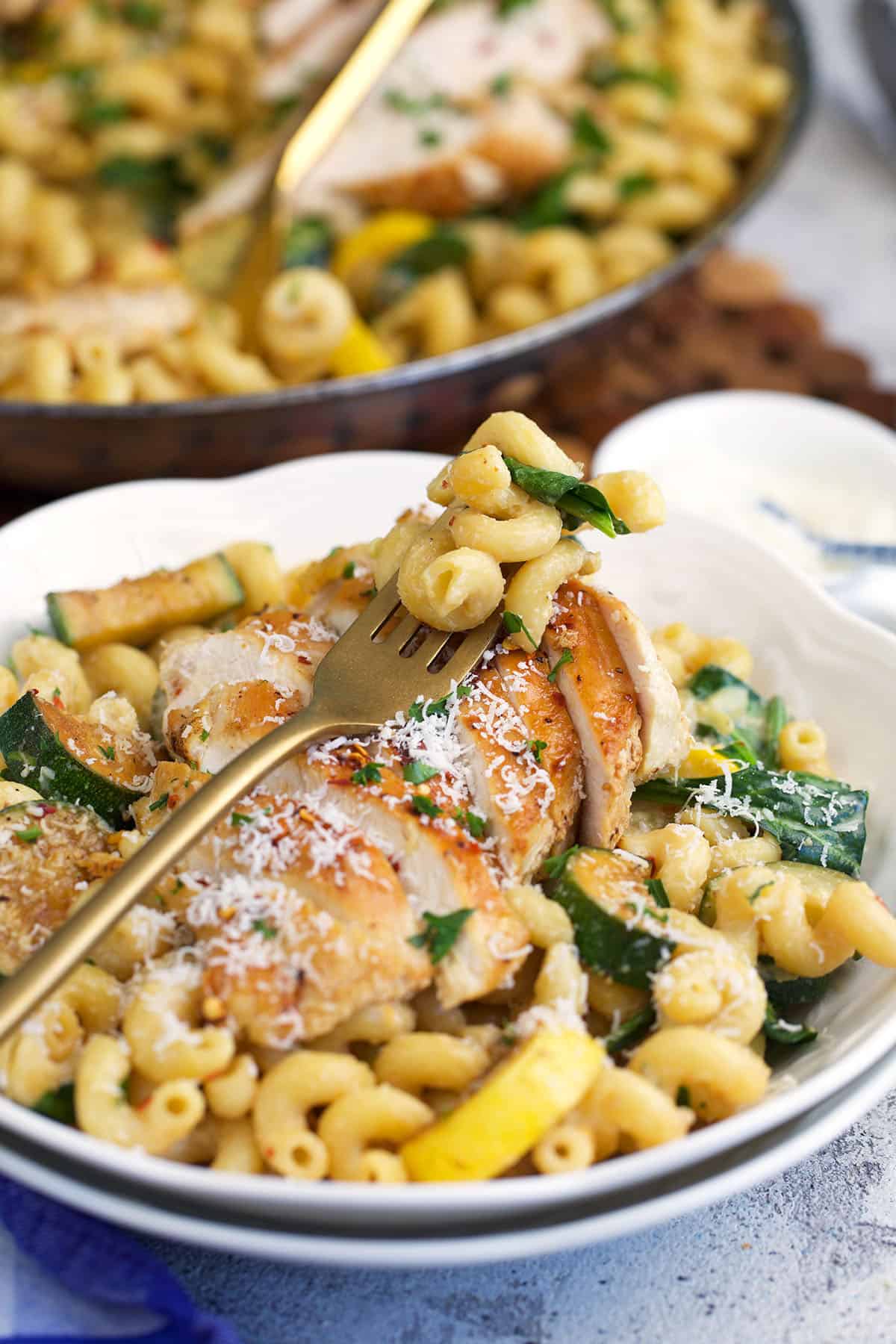 Lemon Chicken Pasta served in a white pasta bowl with a gold fork.