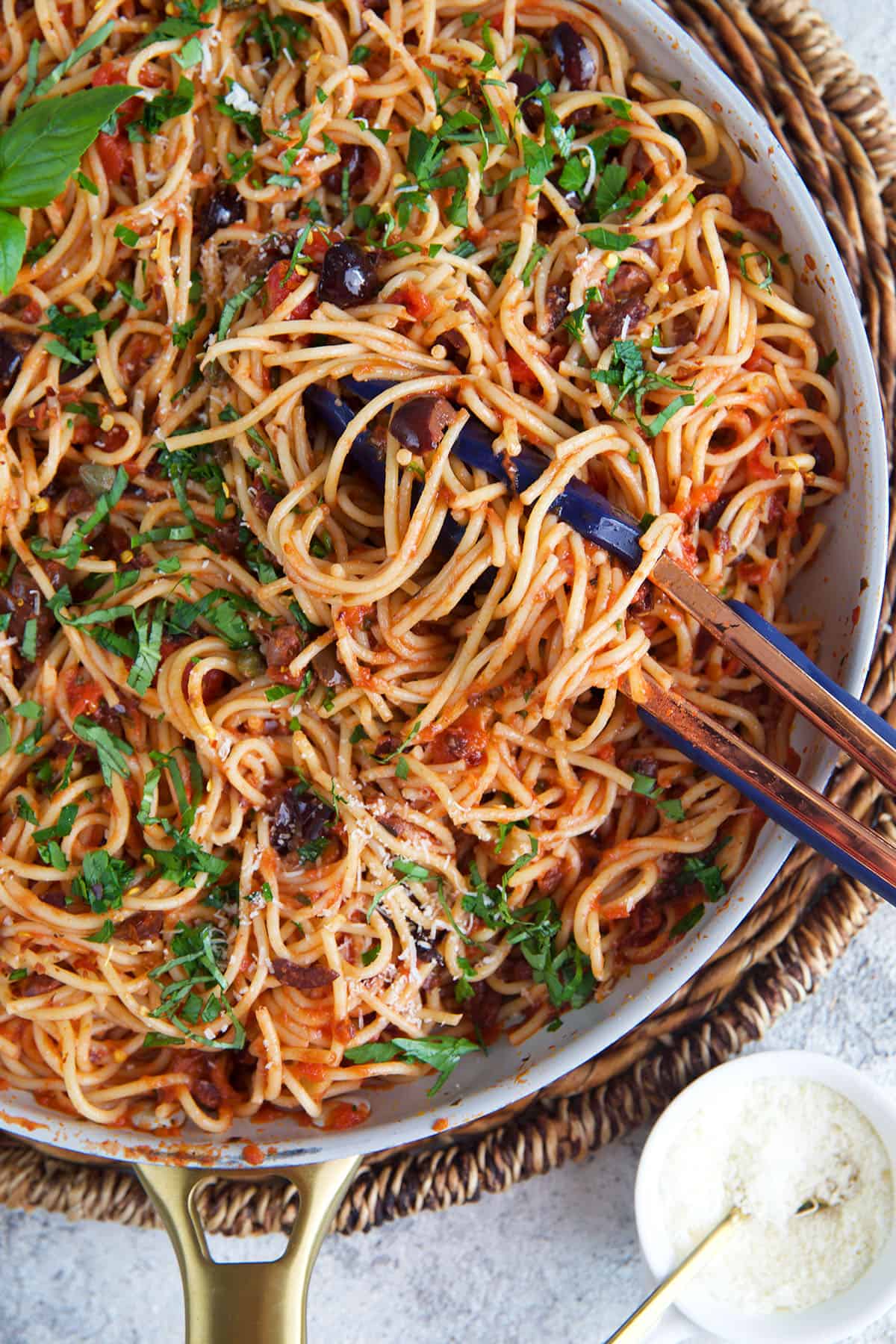 pasta puttanesca being twirled around tongs