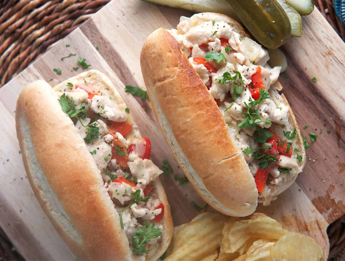 Two chicken cheesesteaks on a serving board
