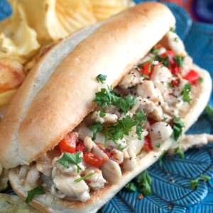 Chicken cheesesteak on a blue plate with chips