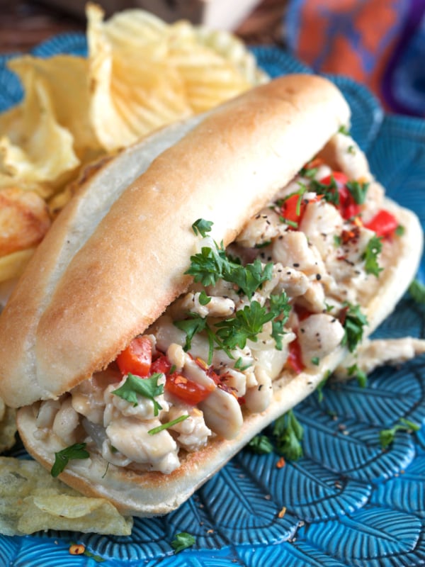 Chicken cheesesteak on a blue plate with chips