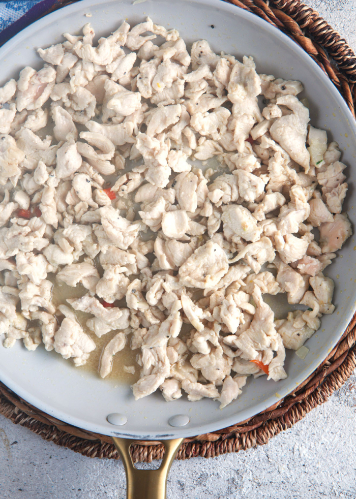 chopped chicken breast being cooked in a skillet