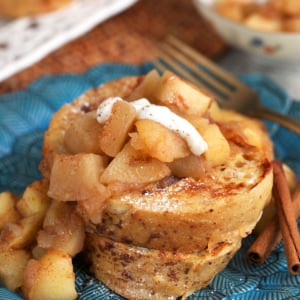 Sourdough French toast stacked on a plate with stewed apples on top