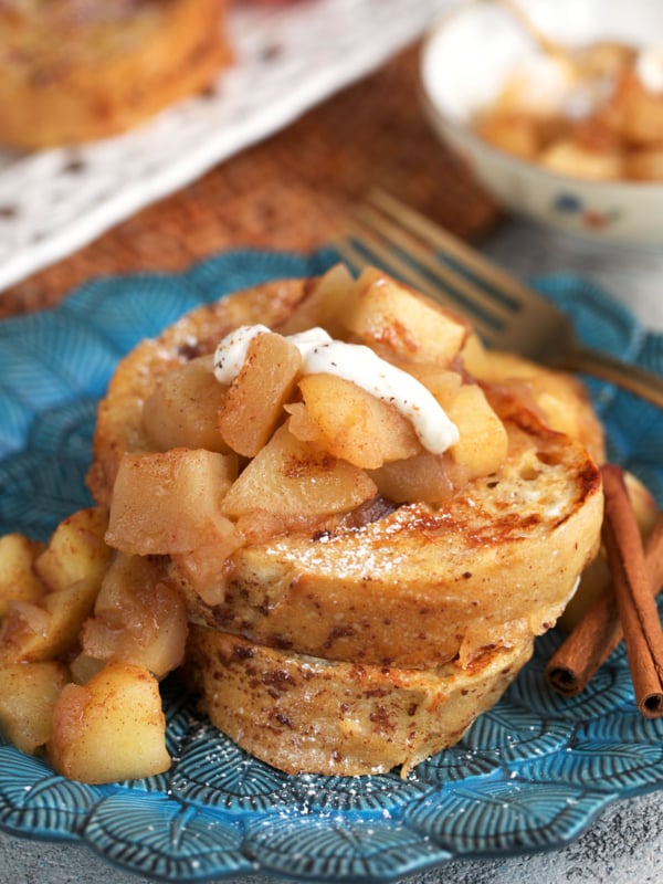 Sourdough French toast stacked on a plate with stewed apples on top