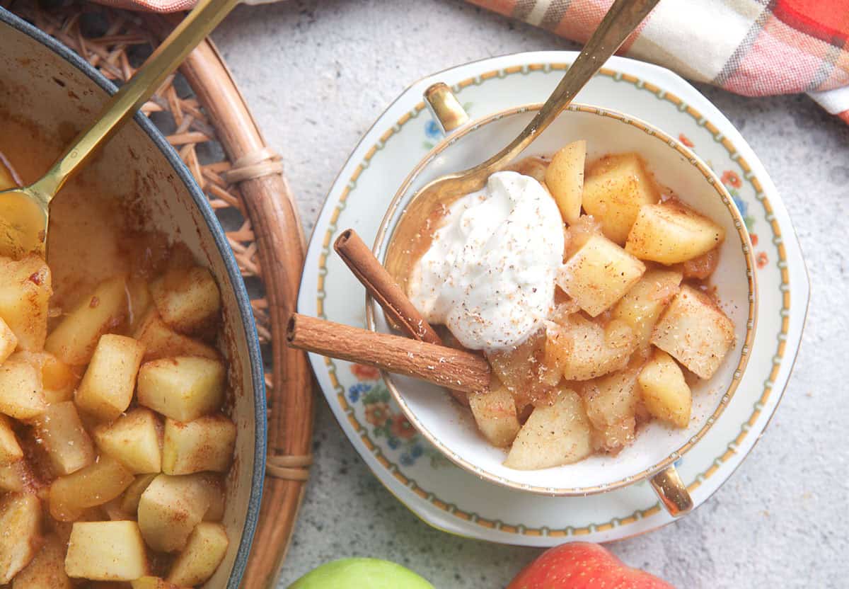 easy stewed apples recipe in a tea cup with cinnamon sticks.