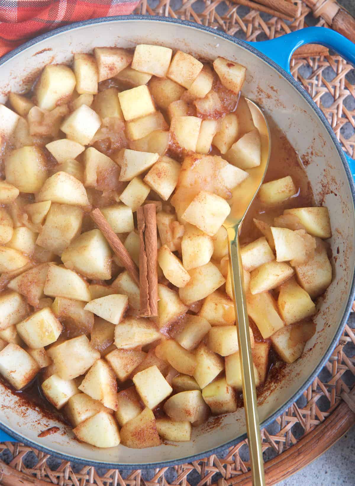 Stewed Apples in a le creuset braised with a gold serving spoon.