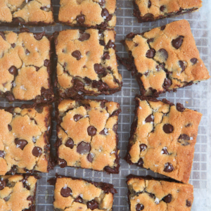 Chocolate chip Cookie Bars cut into squares on a baking cooking wrap