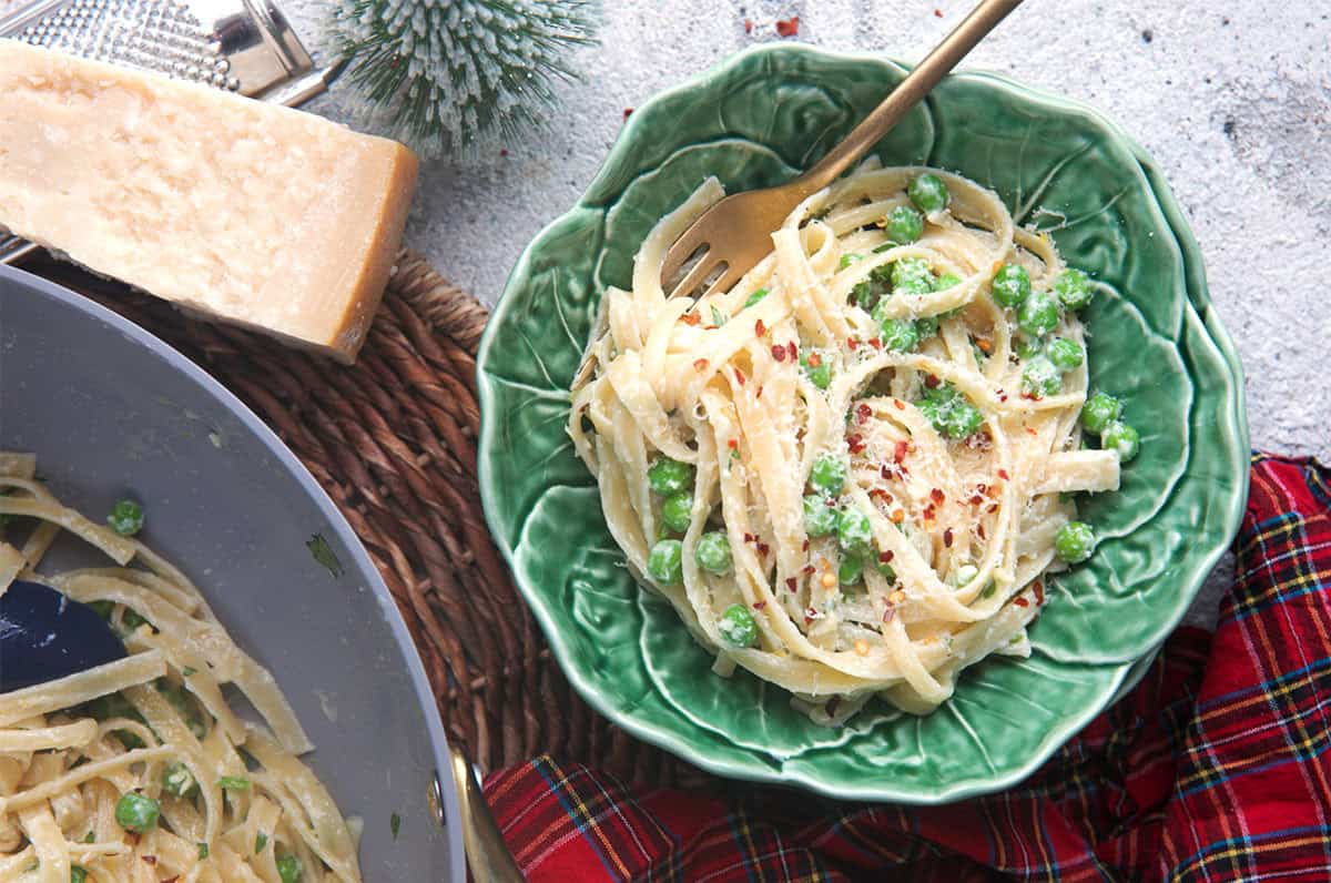 Christmas Fettuccine in a bowl with a wedge of cheese.