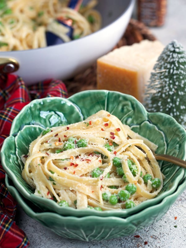 Christmas Fettuccine in a cabbage ware bowl with a skillet of fettuccine already behind it.