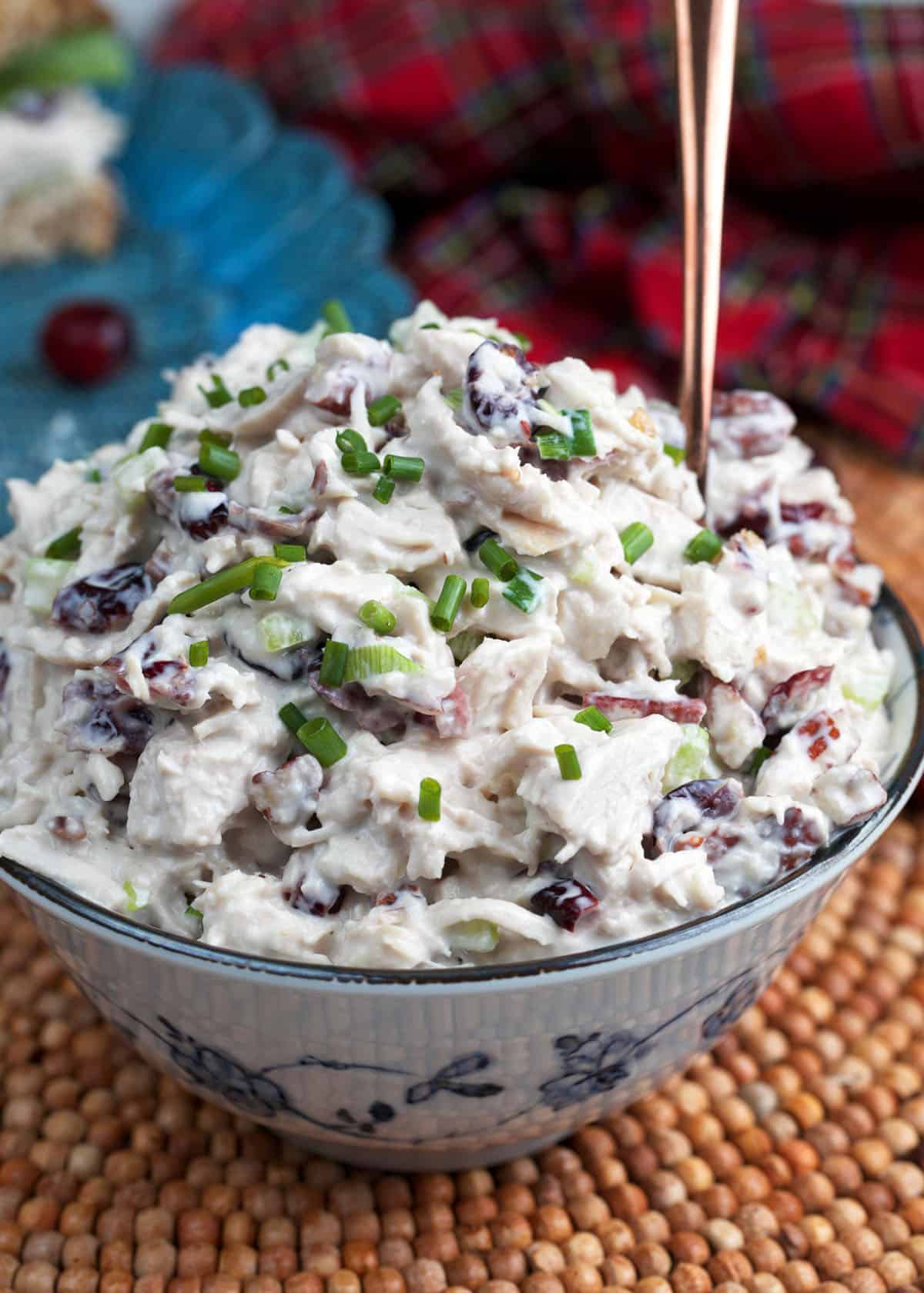Cranberry Chicken Salad in a blue and white serving bowl with a copper spoon
