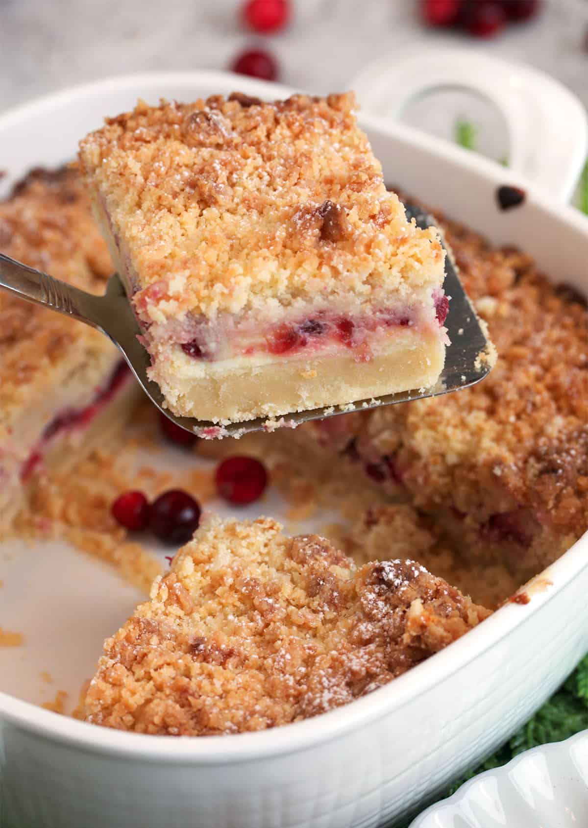 A cranberry cream cheese bar on a small spatula for serving.