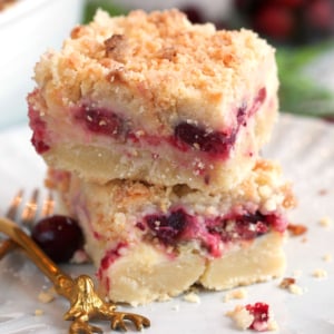 Cranberry Cream Cheese Bars stacked on a white plate.