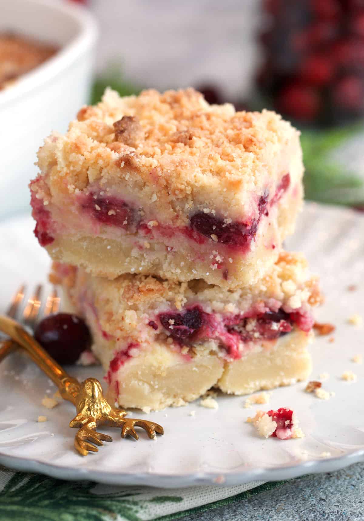 Cranberry Cream Cheese Bars stacked on a white plate.