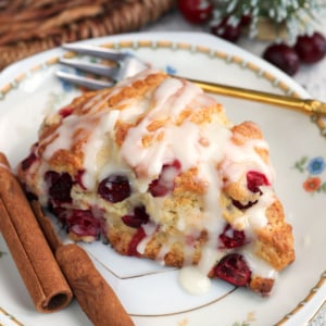 Cranberry Orange Scone on a white china plate with cinnamon sticks.