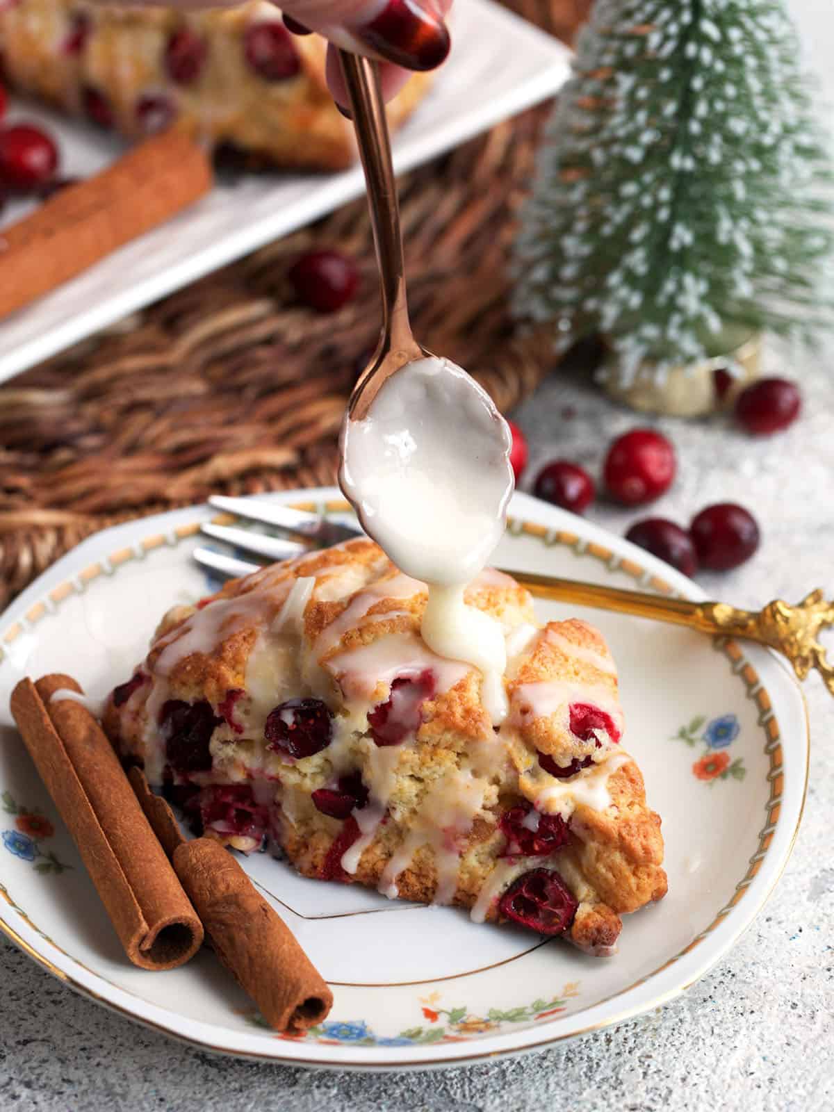 Cranberry Orange Scone being drizzled with orange glaze.