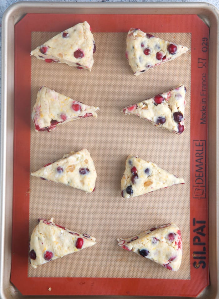 cranberry orange scones on a baking sheet ready to be baked.