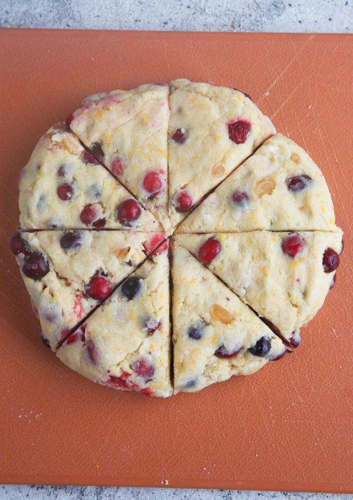 dough for cranberry scones shaped into a circle and cut into 8 wedges