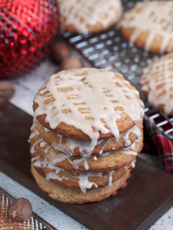 Soft Chai Eggnog Cookies with eggnog glaze on a board.