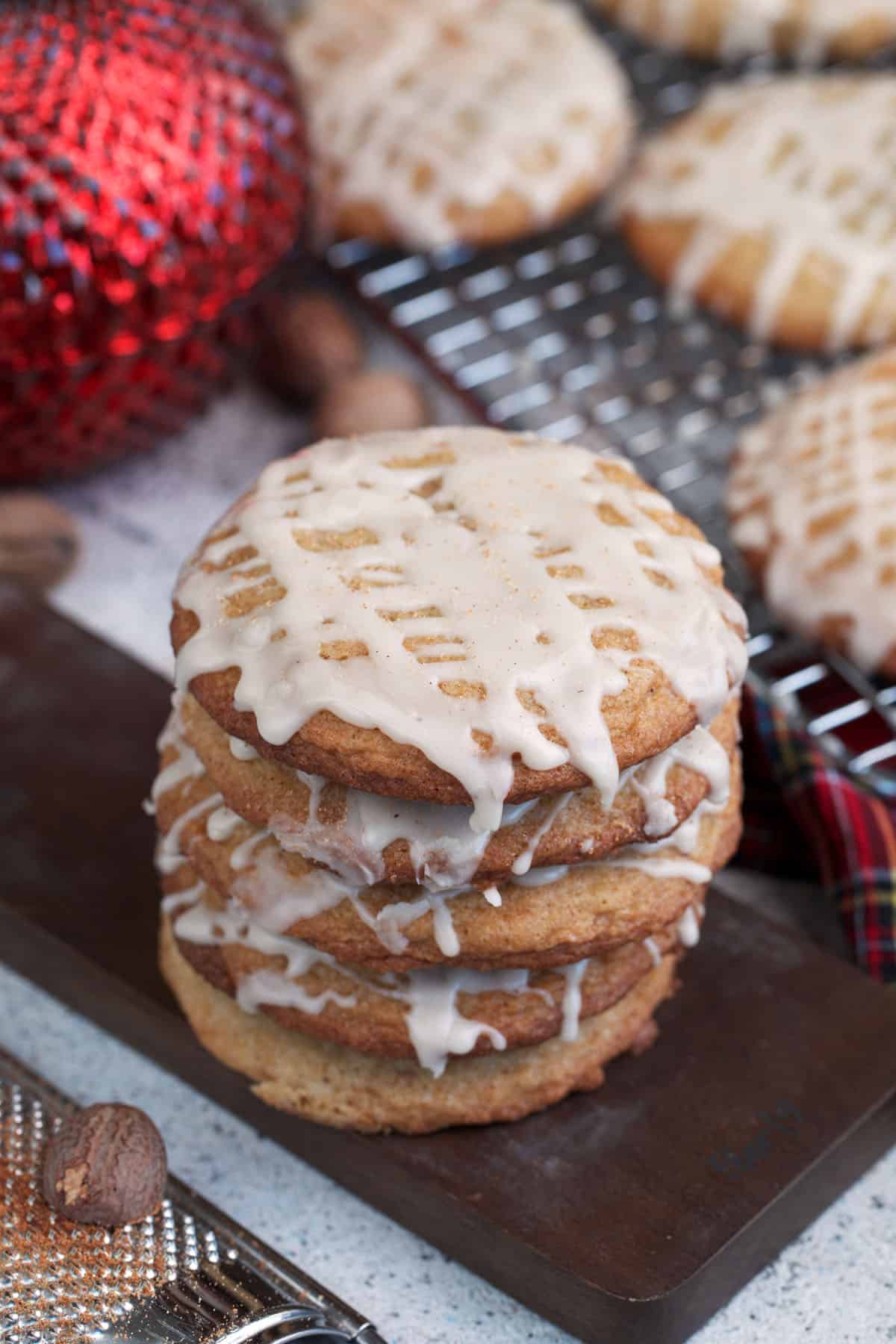 Soft Chai Eggnog Cookies with eggnog glaze on a board.